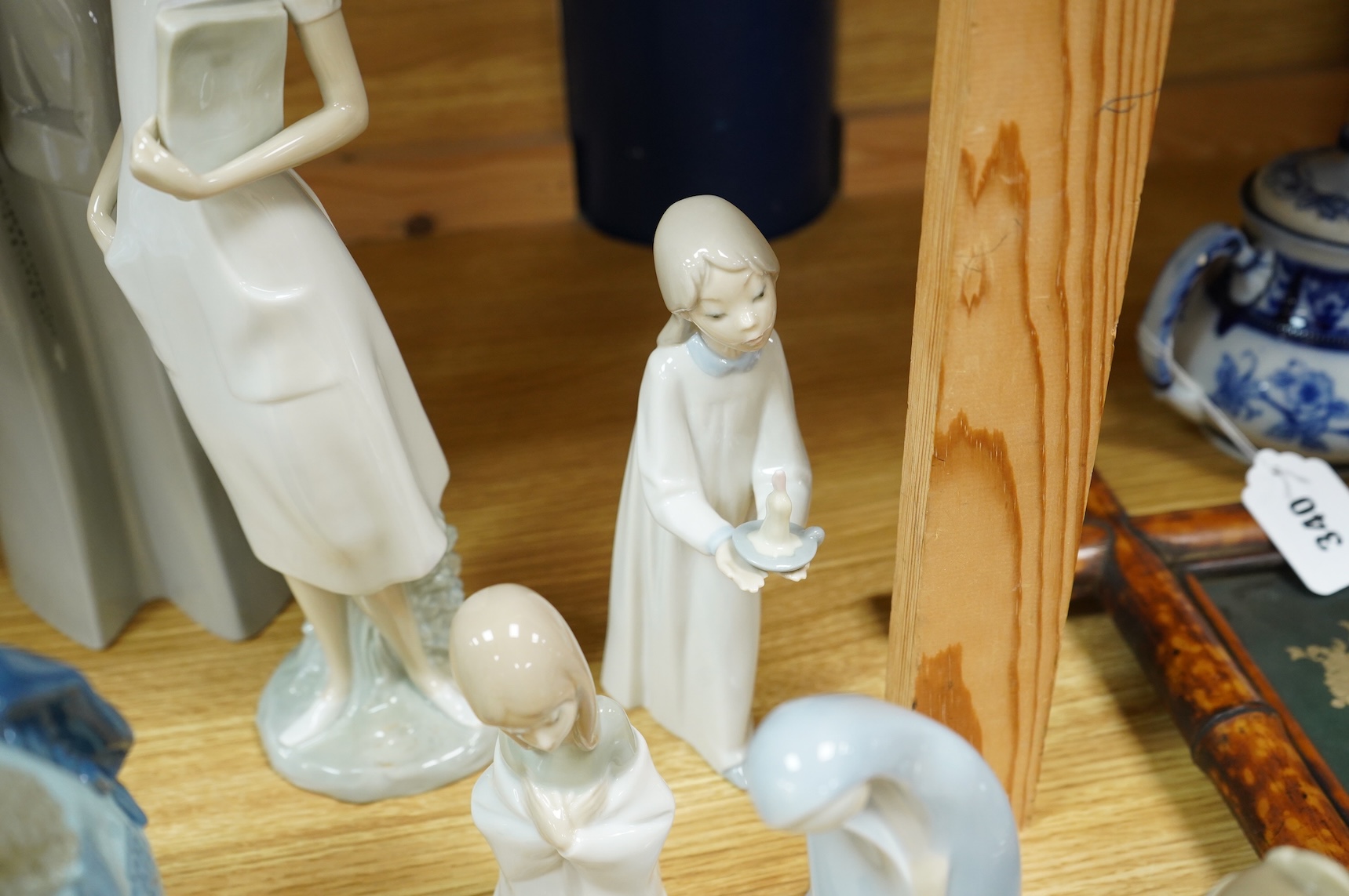 A group of Lladro figures - two Nuns, Geisha, Priest, Virgin Mary, Orange Girl with candle, Girl praying (8) tallest Nuns 33cm high